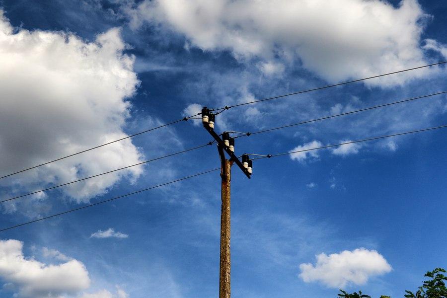 An ordinary utility pole with a simple crossarm and a handful of wires against the sky, showing minimal equipment.