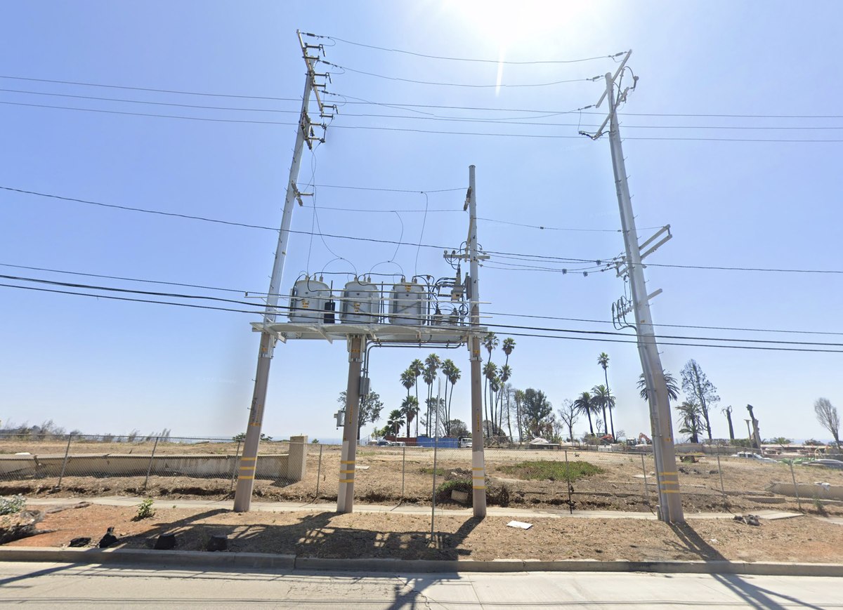 A Pole Top Distribution Station (PTDS) with three transformers mounted on a platform between tall poles.
